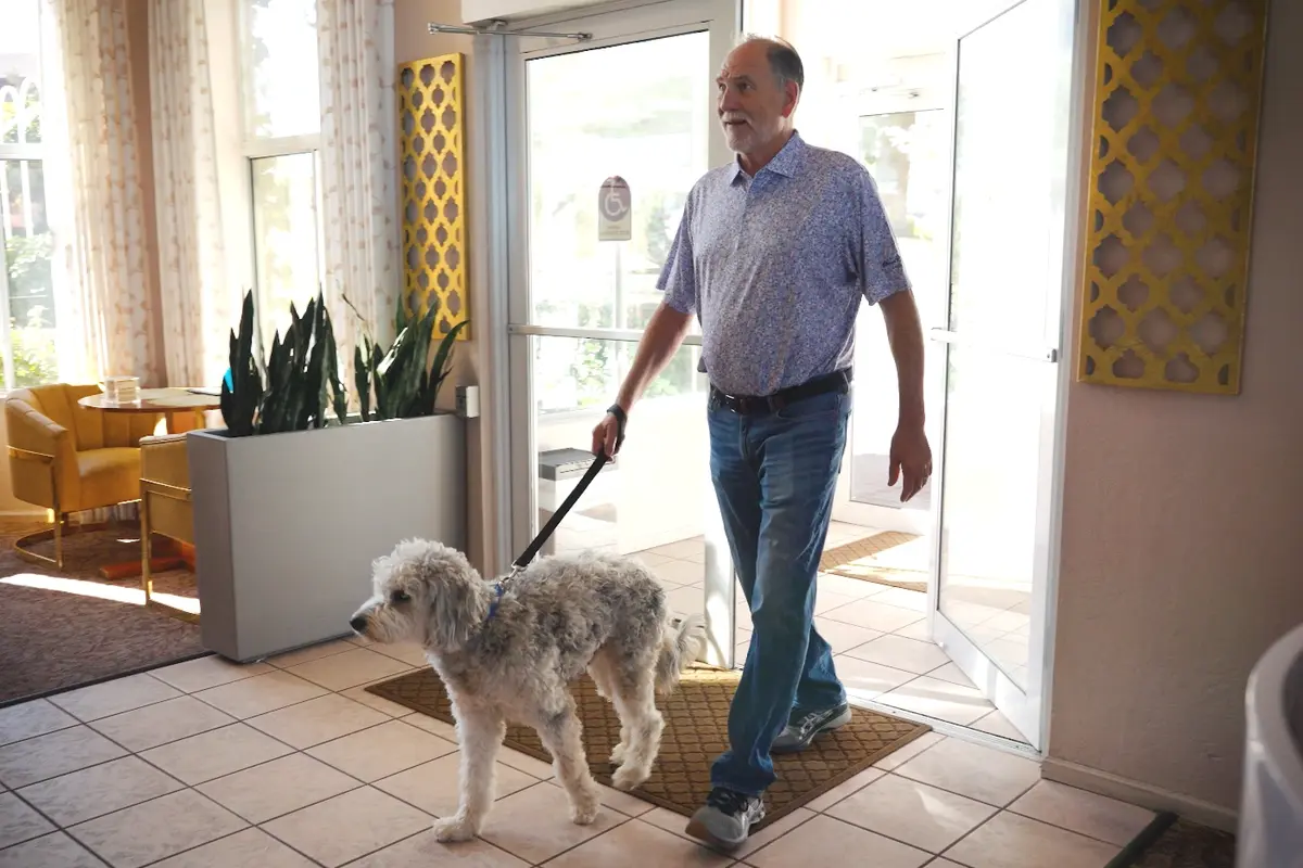 pet-friendly-hotel-prescott-az-dog-check-in Hotel guest walking through the lobby entrance with a leashed dog at a pet friendly hotels prescott az.