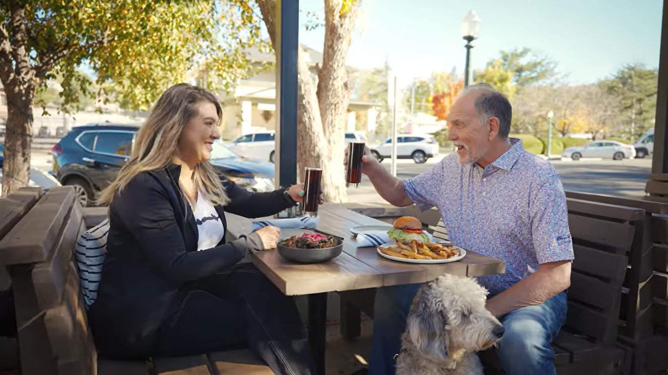 Couple dining at The Barley Hound patio with dog, a pet-friendly restaurant near Forest Villas Hotel in Prescott, AZ